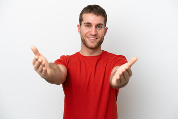 Fototapeta premium Young caucasian man isolated on white background presenting and inviting to come with hand