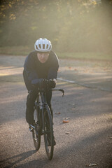 Obraz premium Professional cyclist training to ride fast on the Longchamp year in Paris in the cold winter on a Triahtlon racing bike