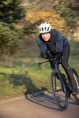 Professional cyclist training to ride fast on the Longchamp year in Paris in the cold winter on a Triahtlon racing bike
