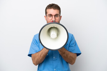 Young surgeon doctor caucasian man isolated on white background shouting through a megaphone