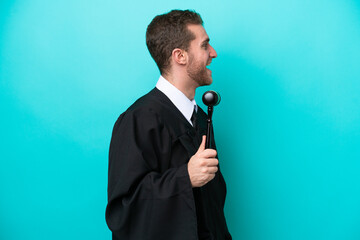Naklejka premium Judge caucasian man isolated on blue background laughing in lateral position