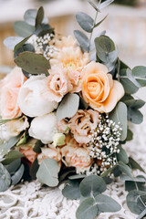 Wedding. Details. A bride's bouquet of flowers and greenery lies on a vintage white table