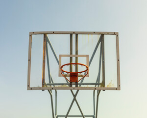 Fototapeta na wymiar Close-up outdoor basketball hoop with transparent backboard and sky background on the street. Street sport concept. Basketball hoop with methacrylate board. copy space