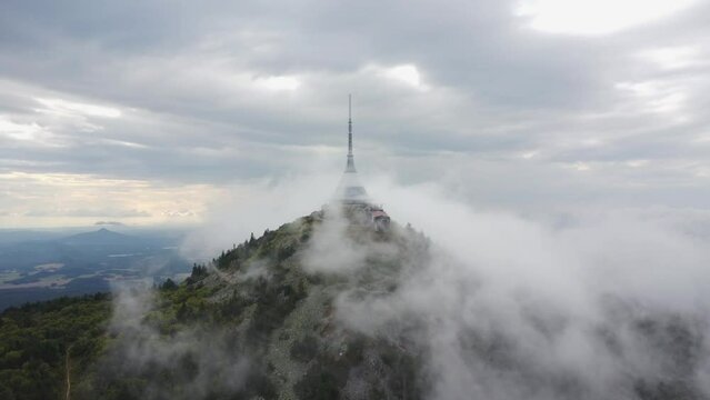 The drone is filming the fog pouring over Jested. The drone is standing still. 4K quality