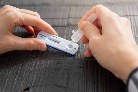 Covid 19 Test At Home. Test Kit And Test Liquid, 2 Hands, Wooden Table. Selftesting.