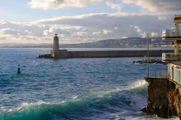 Port in the evening, beacon and the blue sea, lighthouse in the harbor in summer, seascape, Nice, France.
