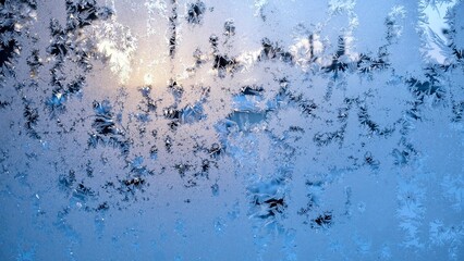 Window glass with frozen drops in the form of white snowflakes on a cold winter evening. Abstract...
