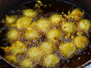 Meatballs are being fried in very hot oil. very crunchy