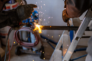 Man welding a gas pipe with flames and sparks