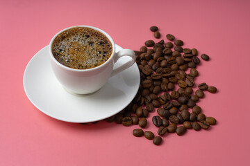 Coffee cup, coffee with beans on pink background. Close up
