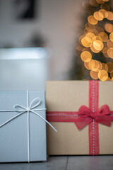Weihnachtlicher Hintergrund mit Platzhalter. Geschenk vor einen beleuchteten Weihnachtsbaum.