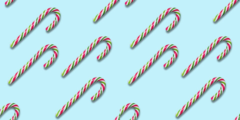 Seamless pattern of Christmas candy cane on a blue background. Flat lay. Xmas flyer or greeting card.