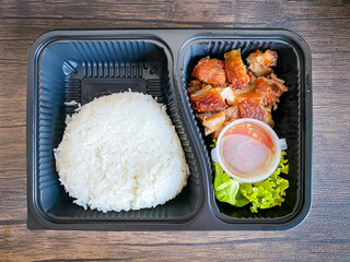 Fried crispy pork with jasmine rice in the food containner