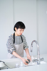 キッチンでお皿を洗う女性 © maru54