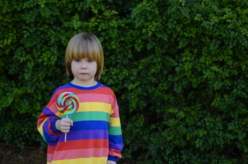 Portrait of a positive little boy. Face close-up. The child smiles sincerely.  Boy with lollipop