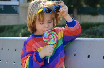 Cute boy in a colorful sweater on the playground. The child laughs, plays, rides down the slide....