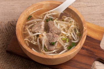 clear stewed pork soup in a wooden bowl