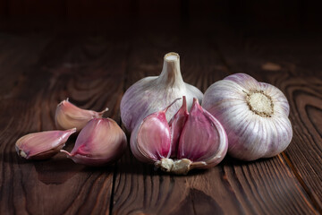 Garlic cloves on wooden table. Fresh peeled garlics and bulbs.