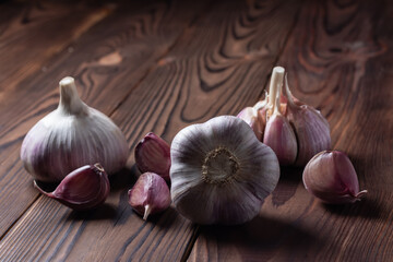 Garlic cloves and bulb on wooden table. Fresh peeled garlics and bulbs.