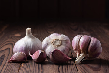 Garlic cloves and bulb on wooden table. Fresh peeled garlics and bulbs.