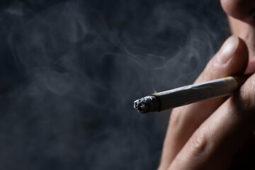 Smoking cigarette in the hand of young man close up