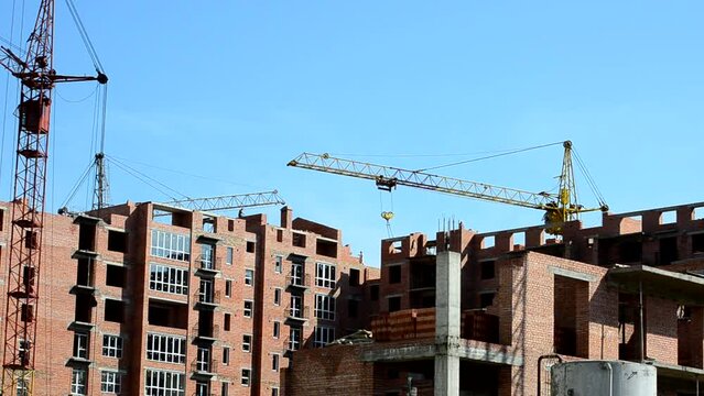 Construction cranes over houses. Construction of residential