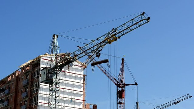 Construction cranes over houses. Construction of residential