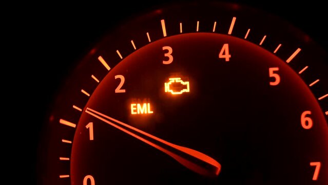 RPM gauge tachometer and moving pointer on dashboard in the car. Check engine light on. 