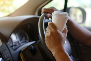 Closeup hand hold paper cup of coffee to drink in car. Concept, baverge for refreshing or helping to awake from asleep during driving that can cause car accident.                  