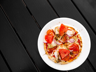 mini pita pizza with Mozzarella cheese, ham, chicken, mushrooms, salami. Italian pizza on wooden table background outdoor