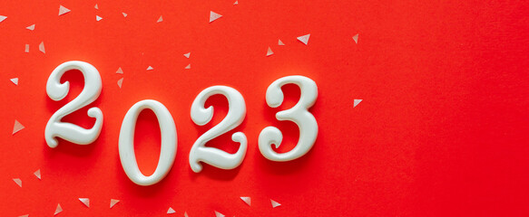 close up number 2023 shape wood on orange color background with geometric confetti for happy new year countdown concept
