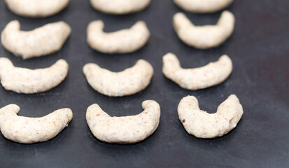 A woman is baking vanilla-flavoured crescent cookies