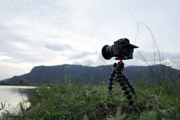 Camera on small tripod with nature mountain landscape, photo trip, lifestyle support for travel...