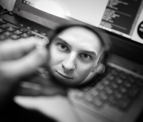 man stare in the round mirror and keyboard background
