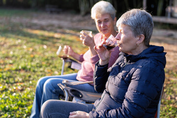 Family aunty mom on holiday travel sit on chair drink morning coffee look green nature relaxation