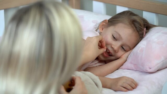 Mother gives sedative medicine to little daughter before sleep. Pills and drugs, medicament, vitamins. Take pill. Medicine and healthcare