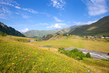 A beautiful mountain landscape with a small meandering river and a blue sky. Mountainous Georgia.