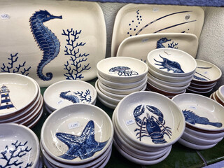 Ceramic craft dishes painted of white blue colors of sea style. Handmade dishes sells in market.