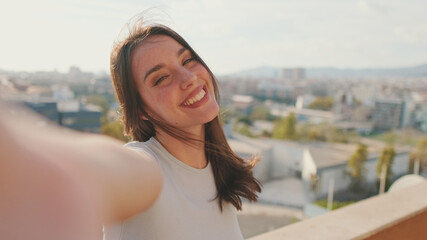 Close-up of young woman taking selfie hand peace sign while standing on balcony