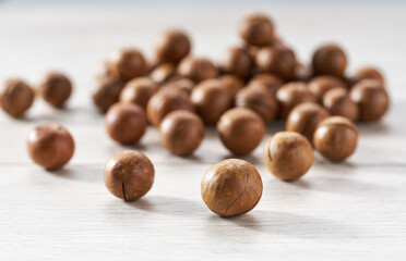 unpeeled macadamia on a white kitchen table, selective focus.