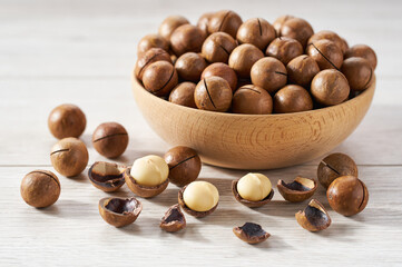 Macadamia  in wooden bowl on white table.