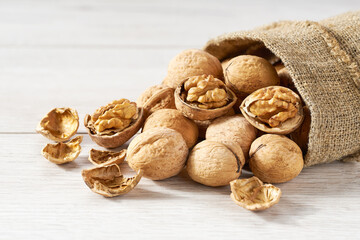 walnuts are poured out of the bag on a white  table, close-up.