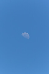 The waning moon in a blue sky. Nature.