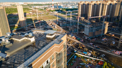 Fototapeta premium Aerial view of a residential high-rise buildings and constructing more next to park and highway in the historical and at same time modern city of St. Petersburg at sunny summer day