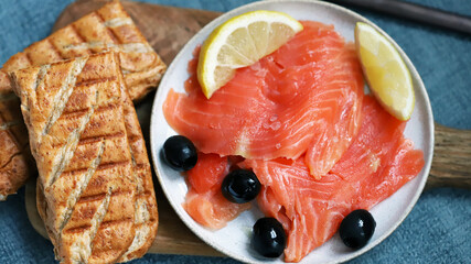 Salted salmon fillet with lemon and olives.