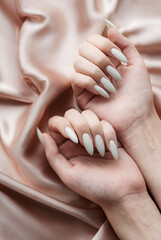 Hands of a young woman with white manicure on nails