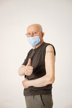 Portrait of an old man with a band-aid on a shoulder isolated on a white background
