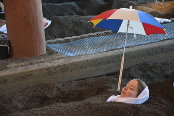 Ibusuki - Unique Onsen Town in Kagoshima, healthy sand and hot spring baths at the coastlinne, people wearing yukata laying in the sand under umbrella