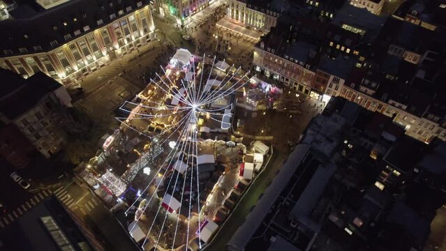 Aerial drone view of Lille, France, at Christmas by night. Amazing 4K video motion from Christmas Market to panoramic view of Wheel and Beffroi