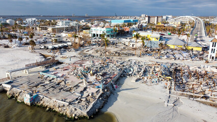 A month after Hurricane Ian brought historic winds and storm surge to the island of Fort Myers Beach, rubble still sits in piles near the shore. 